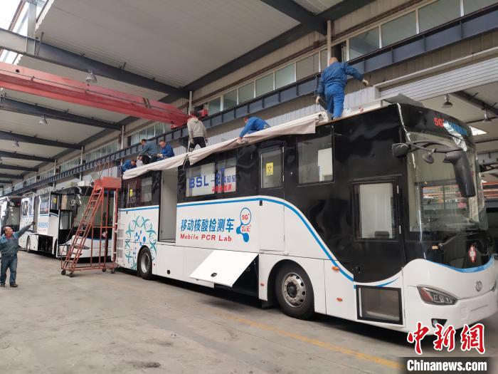 工人在組裝5G智能移動核酸檢測車車頂設備。 王鵬 攝